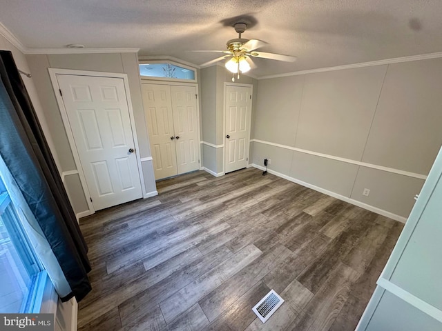 unfurnished bedroom with crown molding, visible vents, ceiling fan, a textured ceiling, and wood finished floors