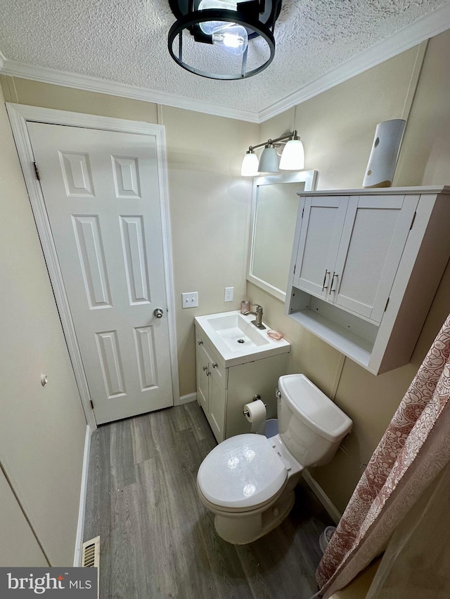 half bath featuring crown molding, a textured ceiling, and wood finished floors