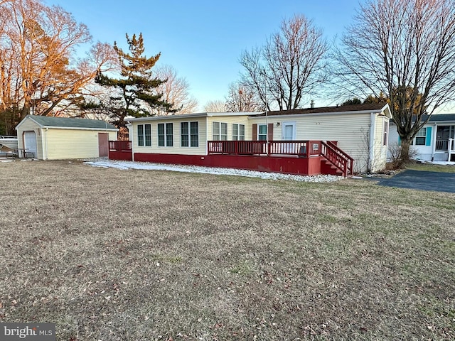 manufactured / mobile home featuring a detached garage, a front yard, and an outdoor structure