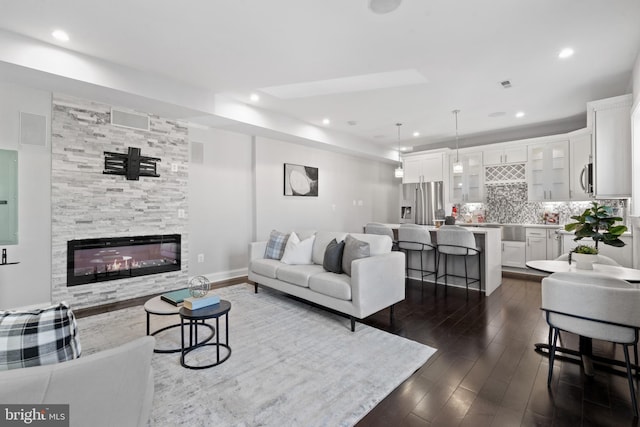 living area with baseboards, electric panel, recessed lighting, a fireplace, and dark wood-style flooring