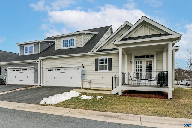 view of front of home featuring covered porch, aphalt driveway, board and batten siding, and a shingled roof