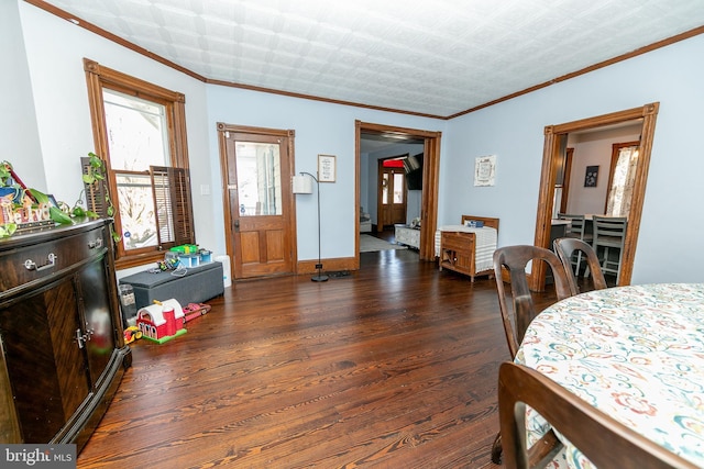 bedroom with ornamental molding, wood finished floors, and baseboards