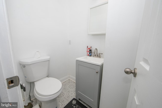 bathroom with toilet, baseboards, and vanity