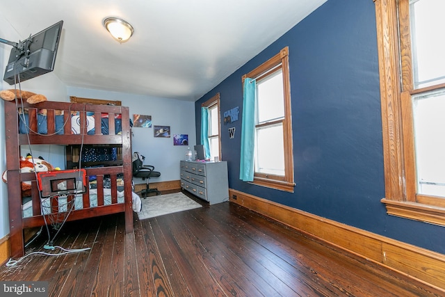 bedroom with wood-type flooring and baseboards