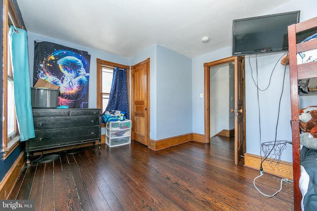 bedroom with hardwood / wood-style floors and baseboards