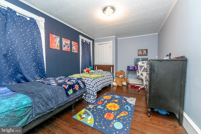 bedroom with ornamental molding, a textured ceiling, and wood finished floors