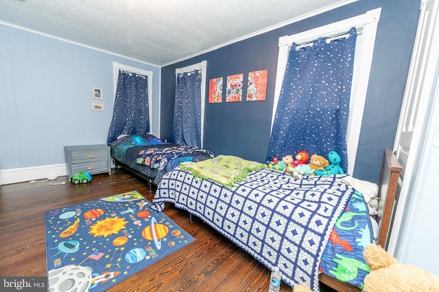 bedroom with crown molding, a textured ceiling, and wood finished floors