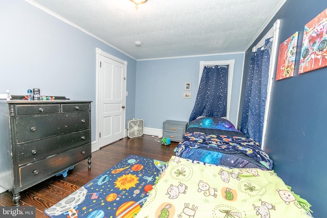 bedroom featuring crown molding, baseboards, and wood finished floors