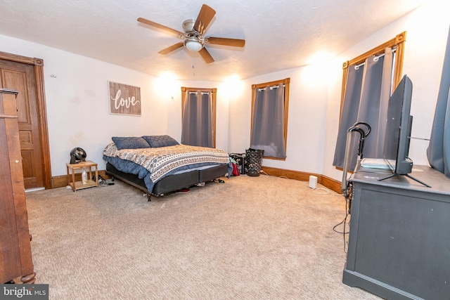 bedroom featuring light colored carpet, ceiling fan, and baseboards