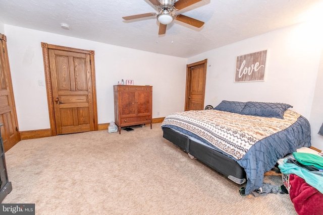 carpeted bedroom with baseboards and a ceiling fan