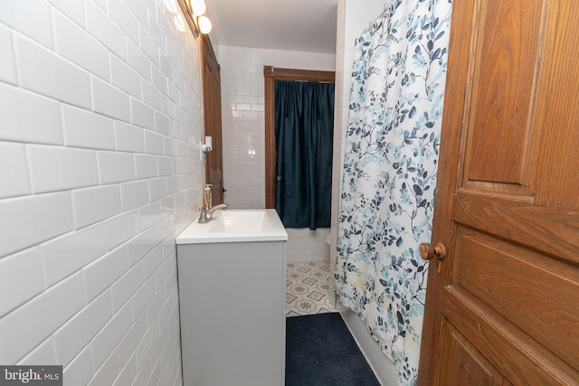 full bath featuring a shower with shower curtain, tile walls, and vanity