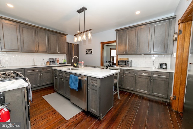 kitchen featuring light stone counters, backsplash, dark wood-type flooring, a sink, and dishwasher