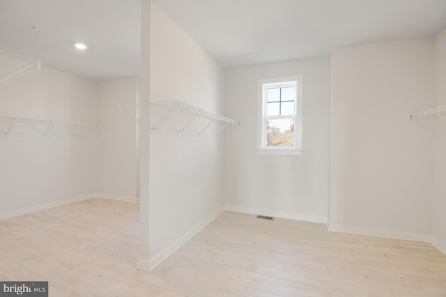 walk in closet with visible vents and wood finished floors