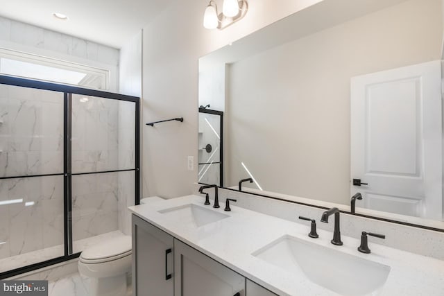 full bath with toilet, marble finish floor, a marble finish shower, and a sink