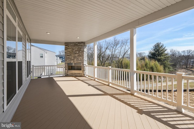 deck featuring an outdoor stone fireplace