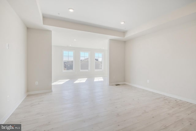 unfurnished room with light wood-type flooring, baseboards, and recessed lighting