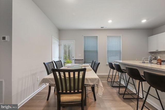 dining space with recessed lighting, wood finished floors, visible vents, and baseboards