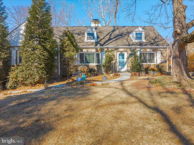 cape cod home featuring a chimney