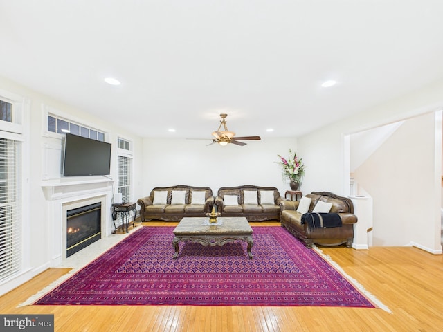 living area with a premium fireplace, wood-type flooring, a ceiling fan, and recessed lighting