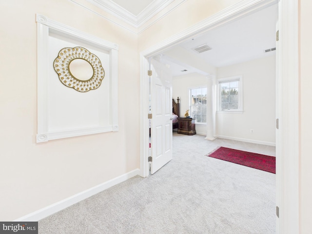 entryway with carpet floors, visible vents, ornamental molding, and baseboards