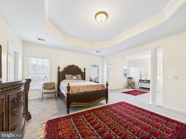 bedroom featuring a tray ceiling, multiple windows, visible vents, and ornate columns