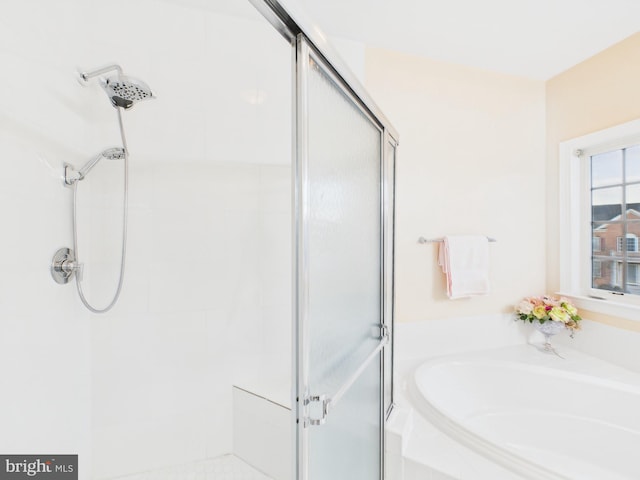 bathroom featuring a stall shower and a garden tub