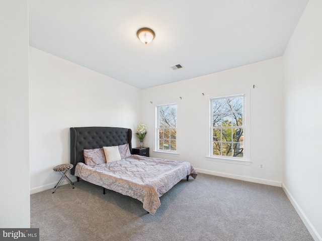 carpeted bedroom with visible vents and baseboards