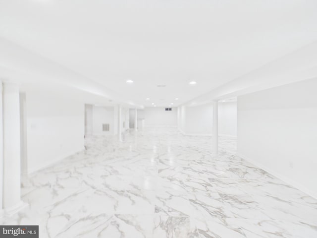 below grade area with marble finish floor, visible vents, and recessed lighting