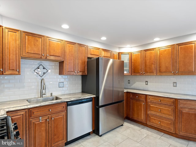 kitchen with light tile patterned floors, recessed lighting, stainless steel appliances, a sink, and brown cabinets