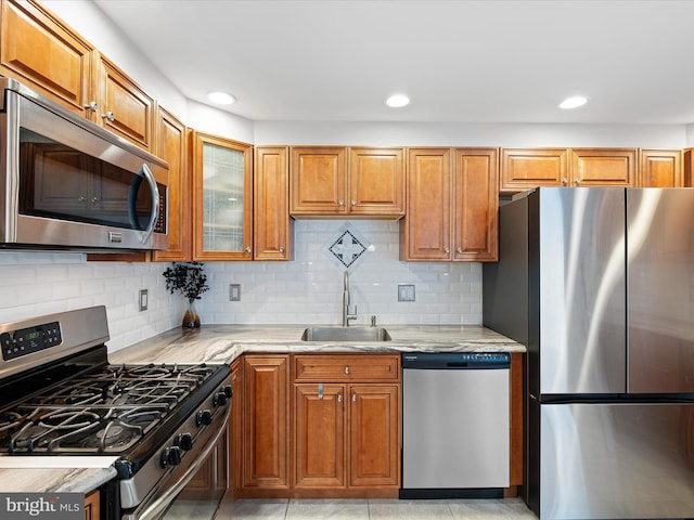 kitchen with brown cabinets, stainless steel appliances, and a sink