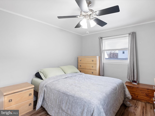 bedroom featuring ceiling fan, ornamental molding, and wood finished floors