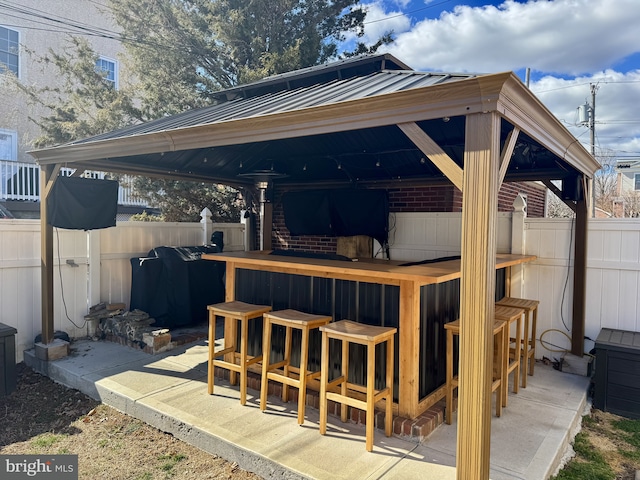 view of patio featuring fence and outdoor dry bar