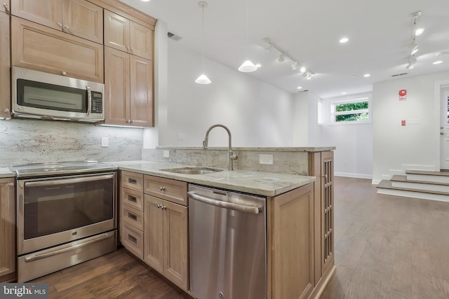 kitchen with a peninsula, a sink, visible vents, appliances with stainless steel finishes, and backsplash