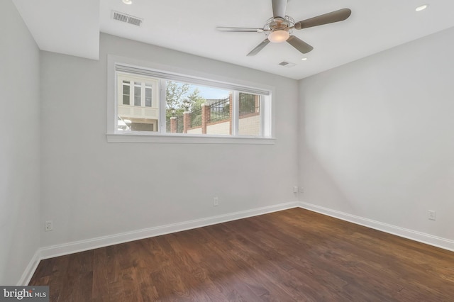 empty room with baseboards, visible vents, ceiling fan, and dark wood-type flooring