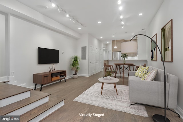 living room featuring recessed lighting, wood finished floors, and baseboards