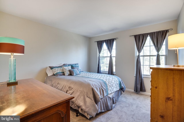 bedroom featuring baseboards and light colored carpet