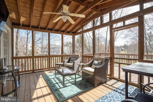 sunroom / solarium with plenty of natural light, lofted ceiling with beams, and ceiling fan