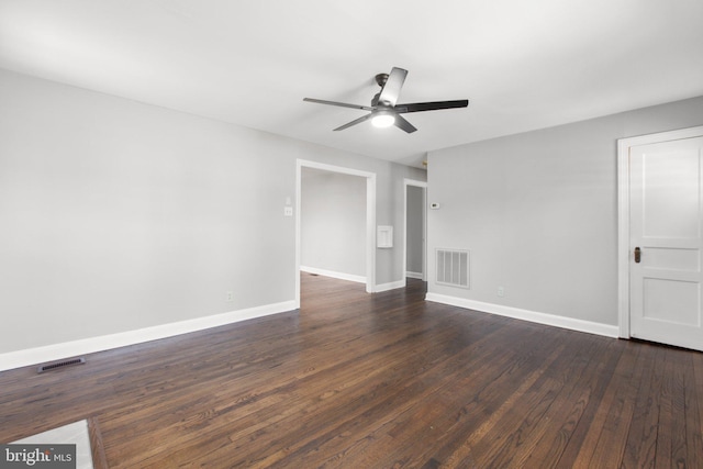 unfurnished room with dark wood-type flooring, a ceiling fan, visible vents, and baseboards