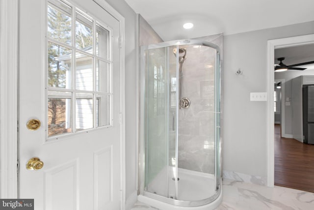 full bath featuring marble finish floor, a shower stall, and baseboards