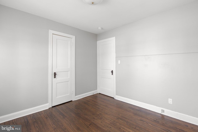 unfurnished bedroom featuring dark wood-style floors and baseboards