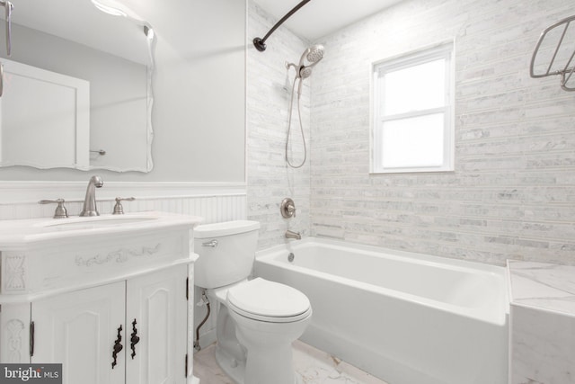 full bath featuring toilet, vanity, shower / bathing tub combination, and wainscoting