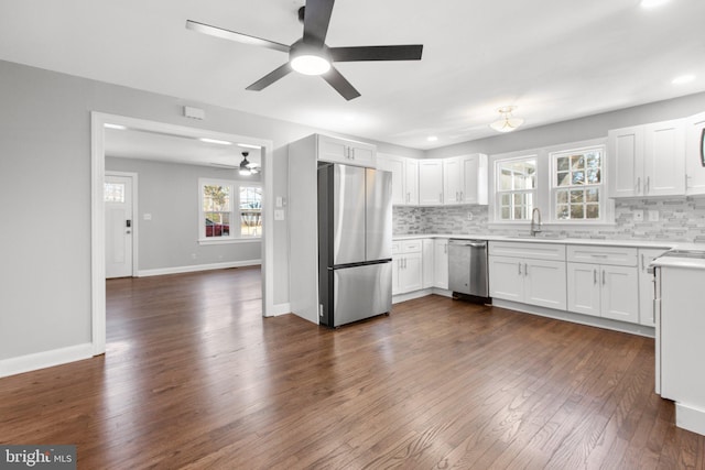 kitchen with tasteful backsplash, dark wood-style floors, stainless steel appliances, light countertops, and white cabinetry