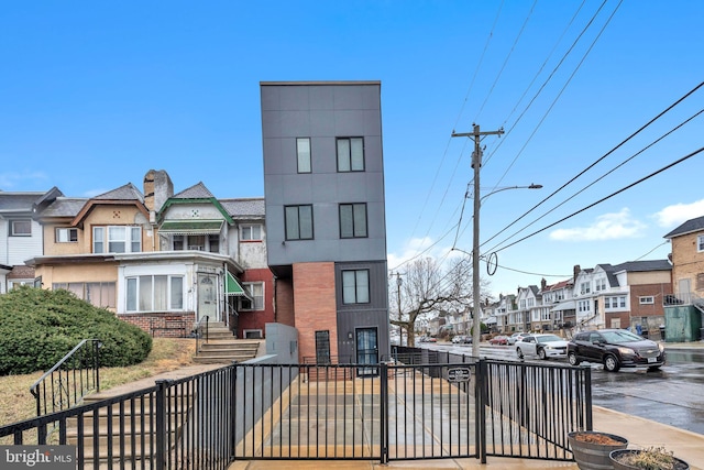 exterior space with a fenced front yard, a residential view, and brick siding