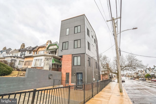 view of building exterior with a fenced front yard and a residential view