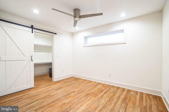 5664 Gainor Rd, Philadelphia, PA 19131 - unfurnished bedroom with recessed lighting, a spacious closet, a barn door, light wood-type flooring, and baseboards
