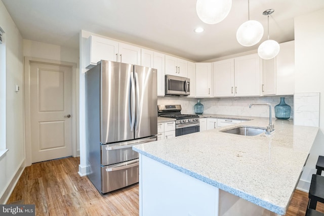 5664 Gainor Rd, Philadelphia, PA 19131 - kitchen featuring stainless steel appliances, backsplash, white cabinetry, a sink, and a peninsula