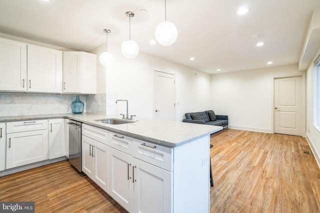 5664 Gainor Rd, Philadelphia, PA 19131 - kitchen featuring white cabinetry, a sink, light wood-style flooring, and decorative backsplash
