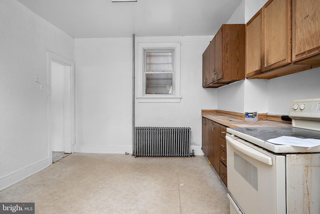 kitchen with white electric stove, radiator heating unit, brown cabinets, light countertops, and concrete flooring