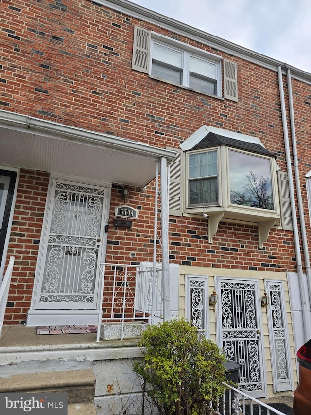 view of exterior entry featuring brick siding