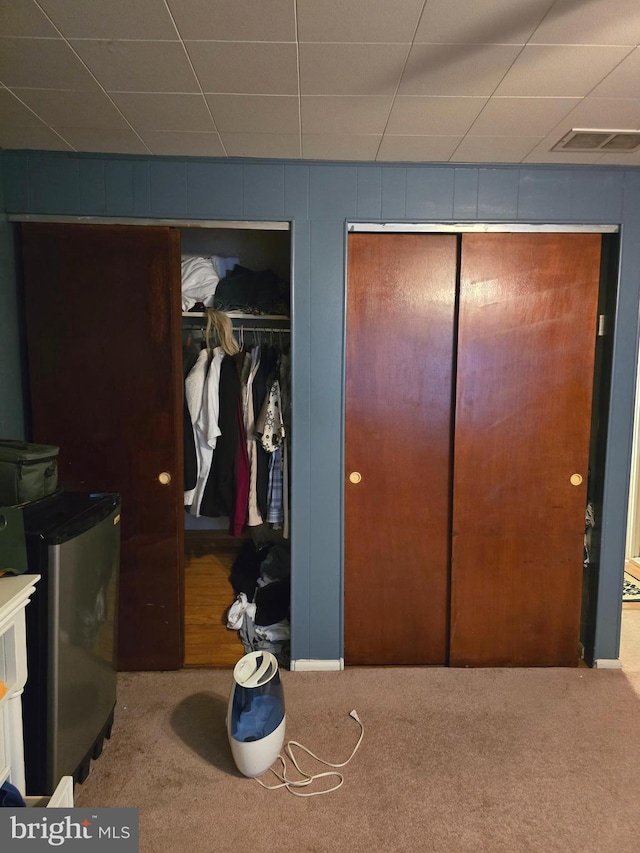 carpeted bedroom with visible vents and multiple closets